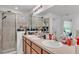 Bright bathroom featuring double vanity sinks with framed mirror and glass enclosed shower at 513 Kimbrel Ct, Haines City, FL 33844