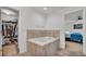 Bright bathroom features a soaking tub with tile surround, with a view of a walk-in closet and bedroom at 513 Kimbrel Ct, Haines City, FL 33844