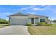 Charming single-story home with a two-car garage, neatly landscaped front yard, and neutral color palette at 513 Kimbrel Ct, Haines City, FL 33844
