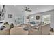Bright and airy living room featuring a ceiling fan, large windows, and comfortable seating at 513 Kimbrel Ct, Haines City, FL 33844