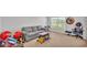 A Gathering living room with carpet, grey couch, toys, white walls, windows, drums, keyboard, and chair at 513 Kimbrel Ct, Haines City, FL 33844