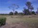 Outdoor view of a grassy backyard with sparse trees seen through a screen window at 5225 Imperial Lakes Blvd # 52, Mulberry, FL 33860