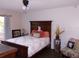 Bedroom with a dark-wood bedframe, neutral walls, and ample natural light from the window at 5225 Imperial Lakes Blvd # 52, Mulberry, FL 33860