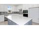 This modern kitchen showcases sleek gray backsplash, white cabinets, and an island with a white countertop at 5844 Sw 87Th Ave, Ocala, FL 34481