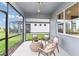Cozy screened patio with comfortable wicker furniture, providing a relaxing outdoor space with a view of the backyard at 5844 Sw 87Th Ave, Ocala, FL 34481