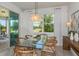Elegant dining area with a modern chandelier, glass table, and natural light streaming through large windows at 8199 Sw 52Nd Lane Rd, Ocala, FL 34481