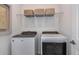 This modern laundry room has front loading washer and dryer appliances with a shelf containing stylish woven baskets above at 8199 Sw 52Nd Lane Rd, Ocala, FL 34481