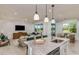 Open concept space boasts kitchen island, dining area, and a cozy living room with large windows at 8199 Sw 52Nd Lane Rd, Ocala, FL 34481