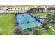 Aerial view of the tennis courts lined with lush green grass at 8283 Sw 54Th Loop, Ocala, FL 34481