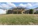 Backyard view of a two-story home, screened-in pool and grassy area at 2523 Jasmine Trace Dr, Kissimmee, FL 34758