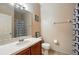 Bathroom features a vanity with sink, toilet, and shower with decorative curtain at 2523 Jasmine Trace Dr, Kissimmee, FL 34758