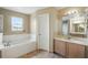 Bright bathroom featuring a soaking tub, a window and vanity with a sink at 2523 Jasmine Trace Dr, Kissimmee, FL 34758