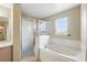 Well-lit bathroom featuring a glass shower, soaking tub, and a vanity with sink at 2523 Jasmine Trace Dr, Kissimmee, FL 34758