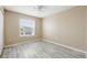 Bright bedroom featuring wood-look flooring and a large window with neighborhood view at 2523 Jasmine Trace Dr, Kissimmee, FL 34758