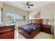 Bedroom features tiled floor, ceiling fan, and large window view of neighborhood at 2523 Jasmine Trace Dr, Kissimmee, FL 34758