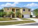 Stunning two-story home with manicured lawn, mature palm trees, and a white two car garage at 2523 Jasmine Trace Dr, Kissimmee, FL 34758