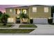 Charming two-story home, complete with a two-car garage, lush lawn and mature palm trees at 2523 Jasmine Trace Dr, Kissimmee, FL 34758