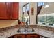 Kitchen sink area featuring granite countertops, wood cabinets, and stainless steel appliances at 2523 Jasmine Trace Dr, Kissimmee, FL 34758