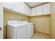 Laundry room features white appliances and cabinets at 2523 Jasmine Trace Dr, Kissimmee, FL 34758