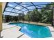 Inviting screened-in pool and spa, perfect for relaxation and entertaining with a backyard view of lush trees at 2523 Jasmine Trace Dr, Kissimmee, FL 34758