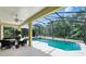 Inviting screened-in pool with outdoor lounge area, perfect for entertaining with a backyard view of lush trees at 2523 Jasmine Trace Dr, Kissimmee, FL 34758