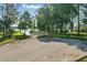 Asphalt parking lot leading to gated pier and lake access with lush greenery and trees at 50989 Highway 27 # 179, Davenport, FL 33897