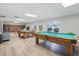Spacious game room with two wooden pool tables, light wood flooring, and a cozy seating area at 50989 Highway 27 # 179, Davenport, FL 33897