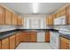 Traditional kitchen with wood cabinets, dark countertops, and white appliances at 50989 Highway 27 # 179, Davenport, FL 33897