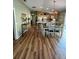 Open-concept layout featuring hardwood floors, adjacent to the kitchen with breakfast bar at 2807 Leicester Ter, The Villages, FL 32162