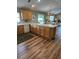 Kitchen featuring wooden cabinets, a breakfast bar, durable flooring and views to the dining and living area at 2807 Leicester Ter, The Villages, FL 32162