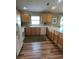 Well-lit kitchen with wooden cabinetry, white appliances, and durable flooring at 2807 Leicester Ter, The Villages, FL 32162