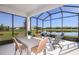 Screened-in patio with a wood table, seating, and views of the water at 5832 Sw 87Th Ave, Ocala, FL 34481