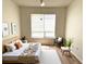 Bright bedroom featuring a neutral color scheme, wood floors, and natural light from a large window at 13103 Mulberry Park Dr # 833, Orlando, FL 32821