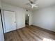 Bright bedroom with wood-look flooring, ceiling fan, and access to the bathroom at 13103 Mulberry Park Dr # 833, Orlando, FL 32821