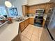 Bright kitchen features stainless steel appliances, wooden cabinets and tile floors at 13103 Mulberry Park Dr # 833, Orlando, FL 32821