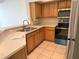 Bright kitchen featuring modern stainless steel appliances, wooden cabinets, and neutral tile flooring at 13103 Mulberry Park Dr # 833, Orlando, FL 32821