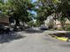 Street view lined with lush trees and parked cars along the side of multi-story apartments at 13103 Mulberry Park Dr # 833, Orlando, FL 32821