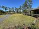 Lush backyard with a detached carport featuring multiple vehicles and a well-maintained lawn at 1275 Man O War Dr, Deland, FL 32724