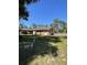 Expansive backyard featuring a brick home, a detached carport, and generous green space at 1275 Man O War Dr, Deland, FL 32724