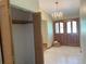 Foyer with hardwood and tile flooring, front doors and closet storage in well-lit entrance at 1275 Man O War Dr, Deland, FL 32724