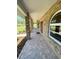 Inviting front porch featuring brick columns and tiled flooring, complemented by the brick facade and landscaped yard at 1275 Man O War Dr, Deland, FL 32724