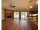 Open-concept kitchen and living room featuring a brick fireplace, hardwood floors, and pool views at 1275 Man O War Dr, Deland, FL 32724