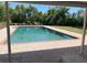 Inviting in-ground pool surrounded by brick patio and lush greenery on a sunny day at 1275 Man O War Dr, Deland, FL 32724