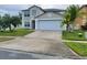 Two-story home featuring a two-car garage, front lawn with palm trees, and neutral-colored exterior at 1416 Aguacate Ct, Orlando, FL 32837