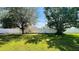 This expansive backyard is enclosed by a tall fence and features lush green grass and mature trees at 3965 Hampton Hills Rd, Lakeland, FL 33810