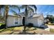 Beige home with lawn, and tropical landscaping on a sunny day at 3965 Hampton Hills Rd, Lakeland, FL 33810