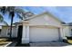 Beige two-story home featuring a two-car garage and a well-maintained lawn at 3965 Hampton Hills Rd, Lakeland, FL 33810