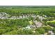 Aerial view of a housing community surrounded by lush trees and nature at 1239 Roycroft Ave, Kissimmee, FL 34747