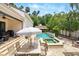 Lush backyard with pool, outdoor kitchen, and patio, perfect for outdoor relaxation and entertaining at 1239 Roycroft Ave, Kissimmee, FL 34747