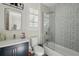 Stylish bathroom featuring a glass-enclosed shower, modern vanity, and patterned accent wall tiles at 1239 Roycroft Ave, Kissimmee, FL 34747